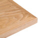 A BFM Seating natural veneer wood table top on a table.