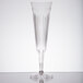 A clear plastic champagne flute with a long stem and a small design.