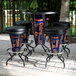A group of Holland Bar Stool University of Florida LED bar stools with black seats and logos on a brick patio.