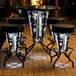 A group of Holland Bar Stool Pittsburgh Penguins LED bar stools on a table with a cup on a stand.