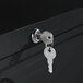 A key in the lock of a black metal Alera lateral file cabinet.