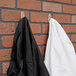 Two black and white coats hanging on 3M Command clear medium hooks.