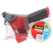 A clear package containing a red and black 3M Scotch heavy-duty tape dispenser gun.