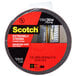 A roll of 3M Scotch black mounting tape with a red label.