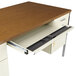 A cherry and putty steel double pedestal desk with an open drawer and metal cabinet.