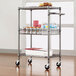 An Alera black anthracite metal cart with food items on it.
