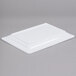 A white rectangular Elite Global Solutions melamine serving platter on a gray surface.