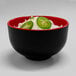A black and red Elite Global Solutions Karma melamine bowl filled with noodles and jalapenos.