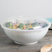 A white Fineline high profile plastic catering bowl with a lid on top filled with salad.