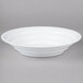 A white Fineline low profile plastic catering bowl on a gray surface.