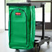 A green bag on a Rubbermaid janitor cart.
