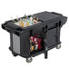 A black Cambro Versa Ultra work table with storage and heavy-duty casters holding bottles of alcohol.
