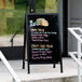 A black Aarco A-Frame sign board with black write-on acrylic board displaying a menu with tacos.