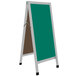 An Aarco aluminum A-frame sign board with green write-on porcelain chalk board panels and black legs.