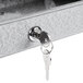 A light gray Aarco outdoor message center key in a keyhole.