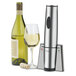 A Waring wine bottle opener next to a glass of wine and a bottle of wine.