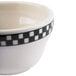 A close-up of a Homer Laughlin creamy white bowl with a black checkered pattern.