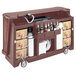 A brown Cambro portable bar with bottles and containers on it.