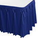 A royal blue Snap Drape table skirt with pleated edges on a table.