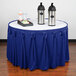 A table with a royal blue Snap Drape table skirt on it with two bottles of liquid.