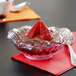 A bowl of chocolate pudding with strawberries topped with a spoon served in a clear dessert dish.