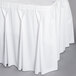 A white Snap Drape table skirt with pleated bow tie edges on a table.