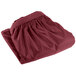 A folded burgundy Snap Drape table skirt on a white background.