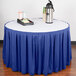 A table with a royal blue Snap Drape table skirt on it and a tray of coffee cups.