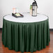 A table with a green table skirt on a table with a green tablecloth and a tray of coffee cups.