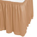 A sandalwood Snap Drape table skirt with shirred pleats on a table.