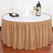 A table with a white tablecloth and a sandalwood shirred pleat table skirt on a table.