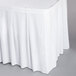 A white Snap Drape table skirt with velcro clips over a white tablecloth.