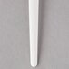 A close up of an Eco-Products Plantware white plastic soup spoon with a handle.
