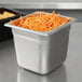 A Choice stainless steel steam table pan filled with shredded carrots and potatoes on a counter.