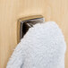 A white towel hanging on a Bobrick metal robe hook.