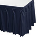 A navy blue Snap Drape table skirt with pleated edges on a table.