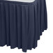 A navy blue Snap Drape box pleat table skirt on a table.