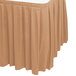 A Snap Drape Sandalwood table skirt with pleated box edges on a table.