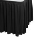 A black Snap Drape box pleat table skirt on a white table.