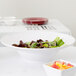An American Metalcraft white melamine serving bowl filled with salad and fruit.