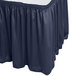 A navy blue Snap Drape shirred pleat table skirt on a table with a white surface.