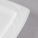 A close up of a Libbey Royal Rideau white porcelain plate with a curved edge.
