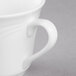 A close-up of a white Libbey Royal Rideau tall porcelain tea cup with a handle.