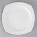 A close up of a Libbey white porcelain plate with a small rim on a gray surface.