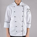 A person wearing a white Chef Revival executive chef coat with black piping.