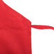 A red Chef Revival bib apron with white strings.