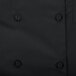 A close up of a black Chef Revival short sleeve chef coat with buttons.