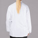 A woman wearing a white Chef Revival long sleeve chef jacket with mesh back.