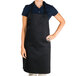 A woman wearing a black Chef Revival bib apron.