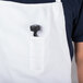 A person wearing a white Chef Revival bib apron with a tool in the pocket.